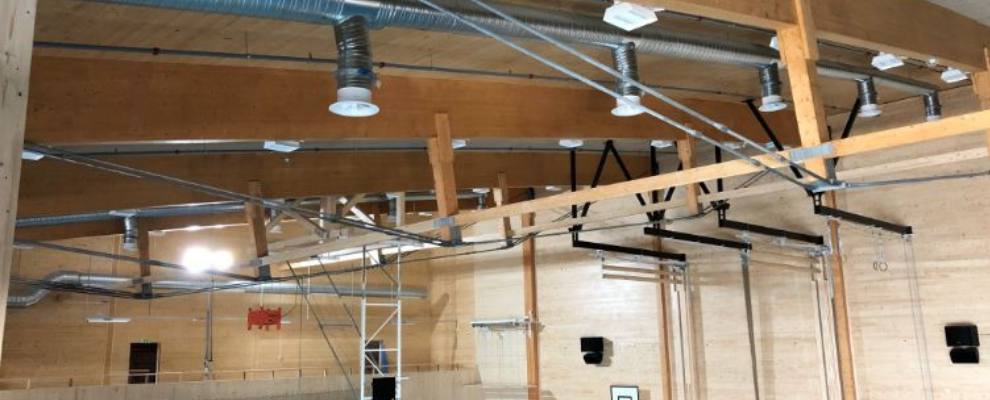 Interiörbild från sporthallen i CIK med synliga installationer i takmiljön.
