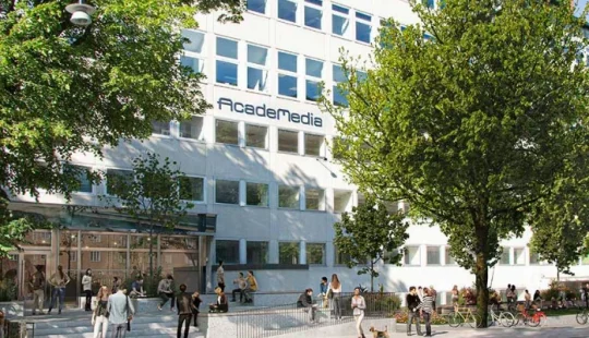 Fasad av en skolbyggnad med AcadeMedia‑skylt i stadsmiljö.