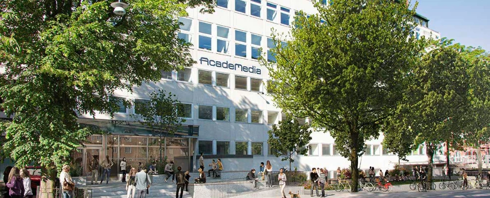 Fasad av en skolbyggnad med AcadeMedia‑skylt i stadsmiljö.