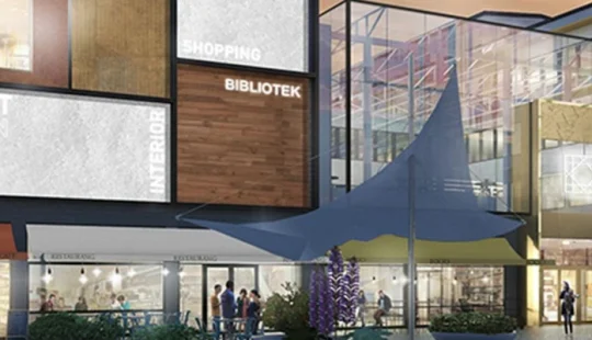 Exteriör av ett köpcentrum med skyltar för shopping, bibliotek och fitness.